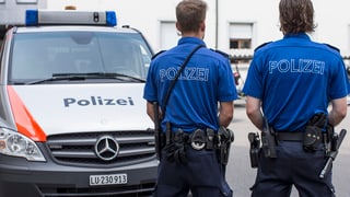 Ein Polizeiauto und zwei bewaffnete Polizisten.