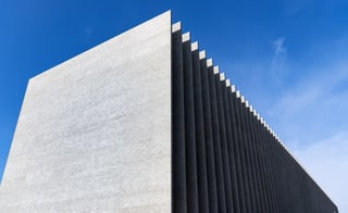 Ein Betonbau mit Lamellen vor blauem Himmel Ein Betonbau mit Lamellen vor blauem Himmel