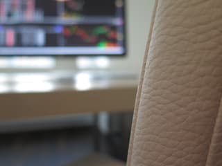 Leerer Sitzplatz vor Computer-Bildschirm des Börsenhändlers