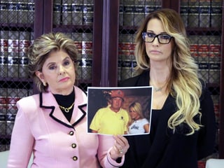Jessica Drake und ihre Anwältin, welche ein Foto von Drake und Trump in der Hand hält. Jessica Drake und ihre Anwältin, welche ein Foto von Drake und Trump in der Hand hält.