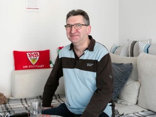 Ein Mann sitzt an einem Küchentisch. Ein Mann sitzt an einem Küchentisch.