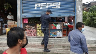 Polizist schliesst einen Laden.