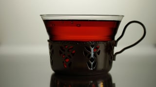Eine Teetasse gefüllt mit rötlich-braunem Tee.