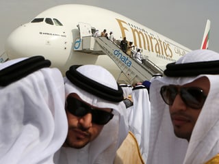 Leute mit Kopftuch vor A380 der Emirates.