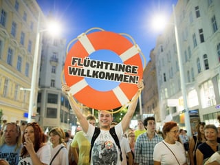 Demonstration in Wien. Demonstrant hält Schild hoch mit der Aufschrift: Flüchtlinge willkommen. 