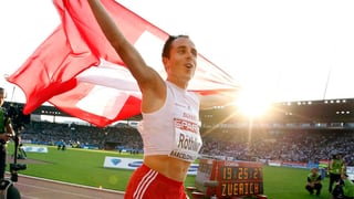 Viktor Röthlin hält die Schweizer Fahne in die Höhe.