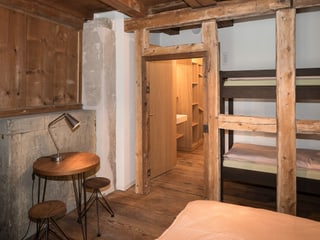 Blick in ein Zimmer, teilweise alte Balken und Mauern, teilweise neue Holzmöbel