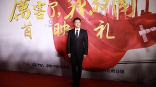 Der chinesische Schauspieler Wu Jing steht vor einem Plakat des Dokumentarfilms «Amazing China».