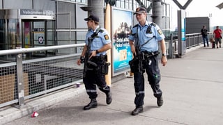 Zwei Polizisten gehen nebeneinander ausserhalb des Terminals des Osloer Flughafens.