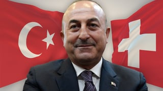 Çavuşoğlu, im Hintergrund die Schweizer und türkische Flagge.