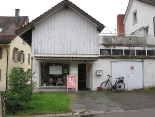 Das Haus der Buchhandlung Pfannenstil. Ein Holzhaus, weiss angestrichen.