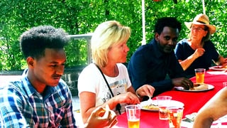 Eritreer und Schweizer beim gemeinsamen Essen.