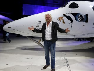 Virgin-Chef Richard Branson steht mit ausgebreiteten Armen vor seinem SpaceShipTwo