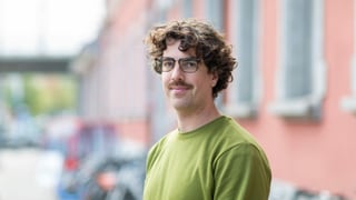 ein junger Mann mit Brille und grünem Pullover ein junger Mann mit Brille und grünem Pullover
