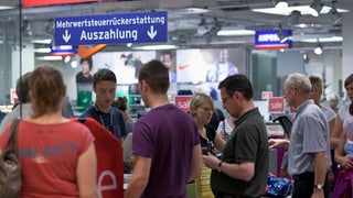 Leute stehen im Einkaufszentrum Lago in Konstanz Schlange, um die Mehrwertsteuer zurückzufordern