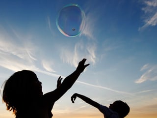 Zwei Kinder - über ihnen fliegt eine Seifenblase Zwei Kinder - über ihnen fliegt eine Seifenblase