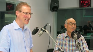 Zwei Männer vor ihren Mikrofonen.