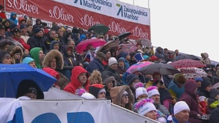 Die Zuschauer in Maribor spannen die Regenschirme auf.
