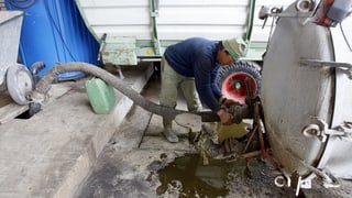 Ein Landwirt pumpt Jauche in sein Güllenfass.