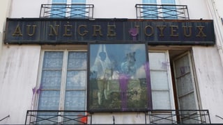 Eine Hauswand mit der Aufschrift «Au nègre joyeux».