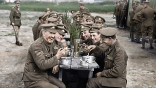 Lachende Soldaten am Mittagstisch während des Ersten Weltkriegs.