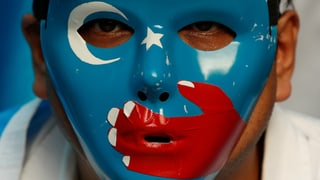 Uigurischer Aktivist mit einer Maske Uigurischer Aktivist mit einer Maske