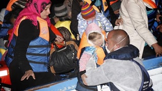 Die italienische Marine nimmt Frauen und Kinder in Empfang, die mit einem Boot aus Libyen geflohen sind.