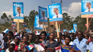 Wahlveranstaltung, Kagames Anhänger halten Schilder mit seinem Wahlplakat in die Höhe.