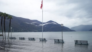 Die Uferpromenade in Ascona ist überschwemmt. Es ragen einige Sitzbänke aus dem Wasser.