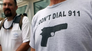 Shirt mit dem Aufdruck "Don't dial 911" und dem Abbild einer Pistole.