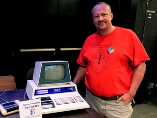 Mann zeigt einen alten Computer.