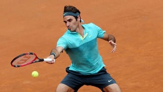 Roger Federer streckt sich mit dem rechten Arm nach einem Ball und spielt ihn zurück übers Netz.