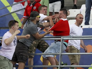 Zwei russische Fans attackieren einen englischen Fan.