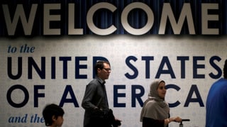 Plakat «Willkommen in den USA» in einem Flughafen.