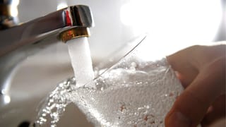 Ein Wasserglas wird am Hahnen aufgefüllt.