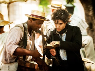 Szene aus dem Film The Cut. ein weisser und ein schwarzer Mann studieren ein Buch.