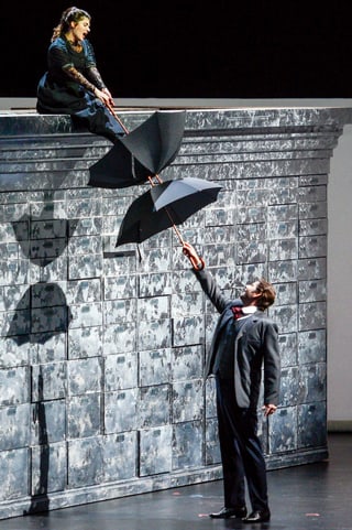 Kathryn Lewek und David Stout mit Regenschirm im Stück «The Merchant of Venice» auf der Bühne.