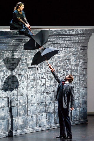 Kathryn Lewek und David Stout mit Regenschirm im Stück «The Merchant of Venice» auf der Bühne. Kathryn Lewek und David Stout mit Regenschirm im Stück «The Merchant of Venice» auf der Bühne.