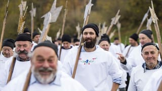 verkleidete Männer in weissen Hemden und mit alten Waffen laufen gemeinsam verkleidete Männer in weissen Hemden und mit alten Waffen laufen gemeinsam