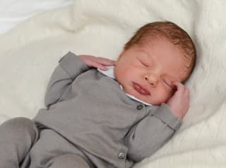 Baby Nicolas Nahe mit geschlossenen Augen in einem grauen Dress