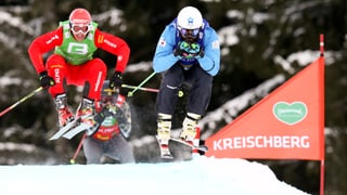 Zwei Skicrosser duellieren sich im Rennen. 