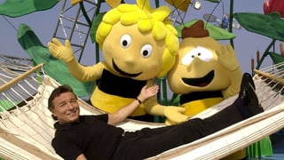 Karel Gott in einer Hängematte liegend mit Biene Maja und Willi als Plüschfiguren.