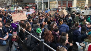 Eine Gruppe von Schülerinnen und Schülern sitzt auf der Bahnhofstrasse. Eine Gruppe von Schülerinnen und Schülern sitzt auf der Bahnhofstrasse.