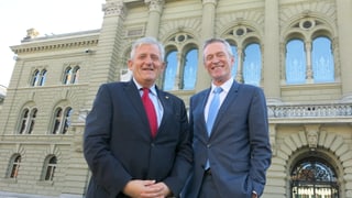 Stöckli und Luginbühl stehen vor dem Bundeshaus und lachen in die Kamera.