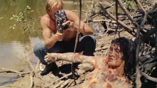 Ein Mann filmt eine blutüberströmte Leiche.