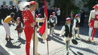 Aufstellung für den Chilbi-Umzug. Männer in historischen Umzügen mit Kindern.