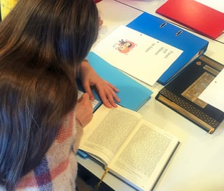 Blick über die Schulter eines jugendlichen Mädchens, das am Tisch sitzt und ein Buch liest. Blick über die Schulter eines jugendlichen Mädchens, das am Tisch sitzt und ein Buch liest.