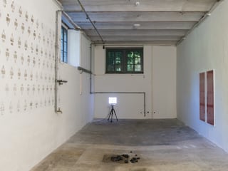 Kellerraum mit weissen Wänden, Wandbild und Baulampe.