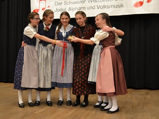 Sechs Mädchen freuen sich auf der Bühne.
