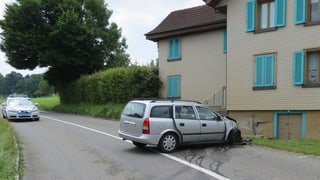 Silbernes Fahrzeug mit eingedrückter Front steht quer in einer leichten Kurve, die Nase an einer Hauswand. Silbernes Fahrzeug mit eingedrückter Front steht quer in einer leichten Kurve, die Nase an einer Hauswand.